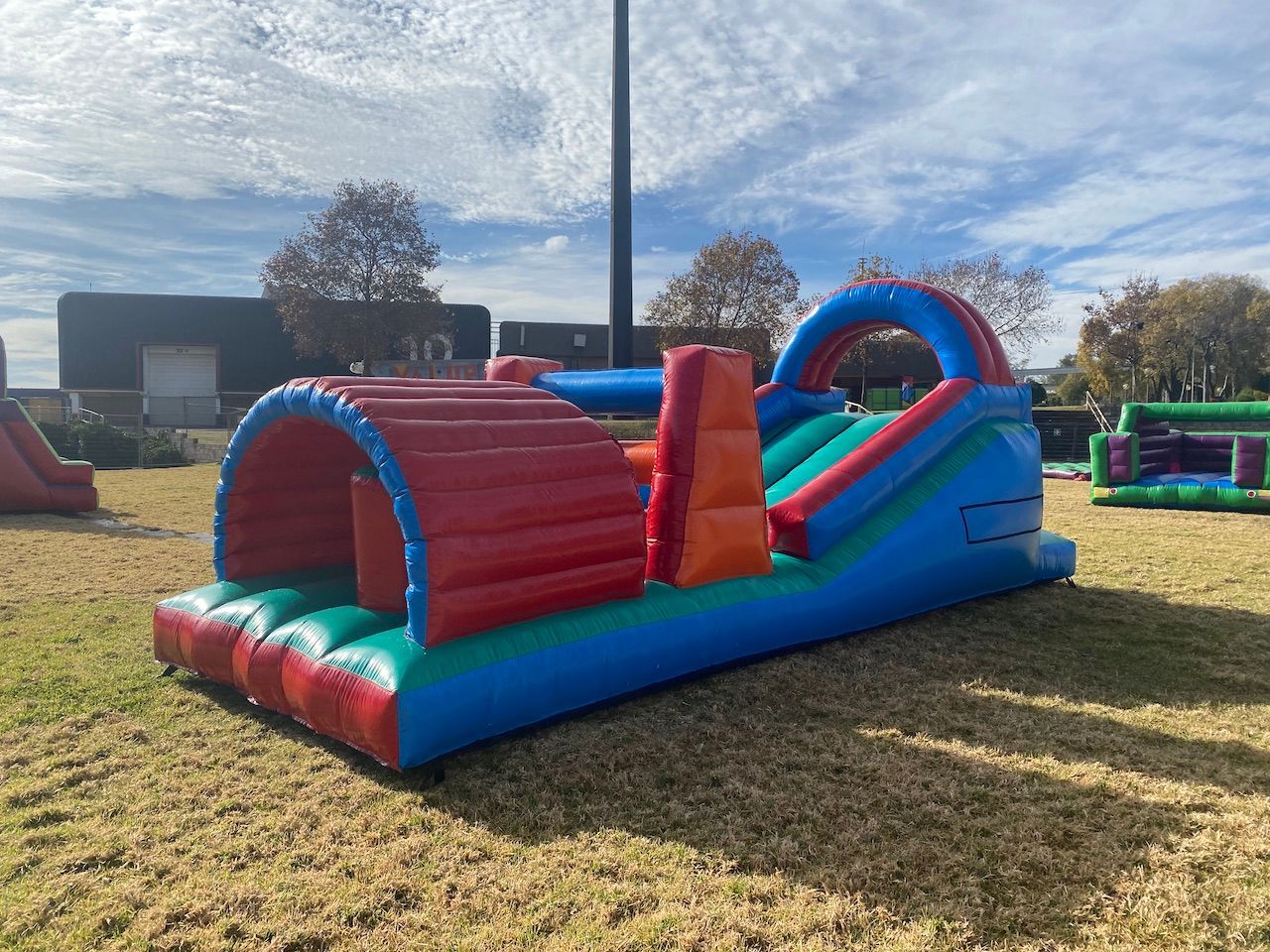 A large inflatable obstacle course is sitting on top of a lush green field.