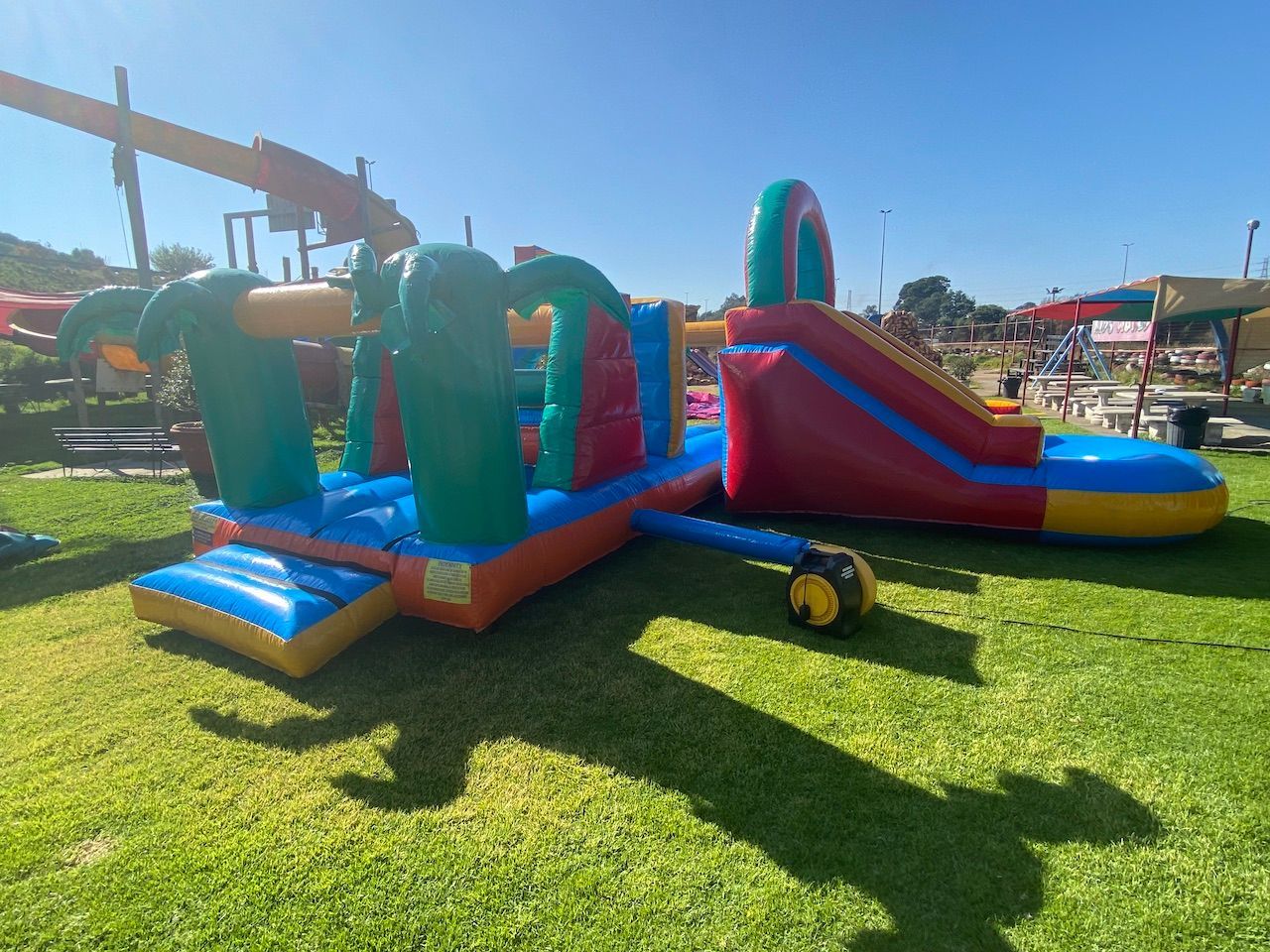 A large bouncy house is sitting on top of a lush green field.