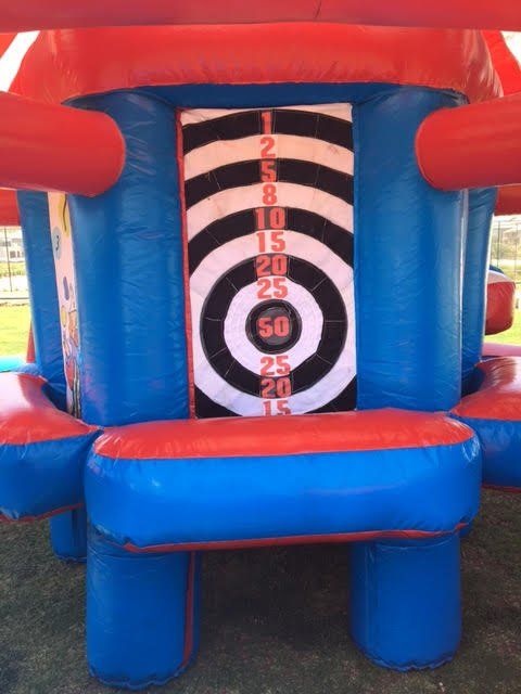 A blue and red inflatable castle with a target on the side.