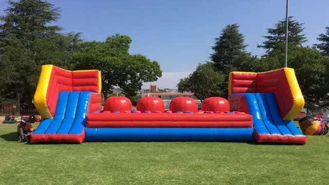 A large inflatable obstacle course is sitting on top of a lush green field.