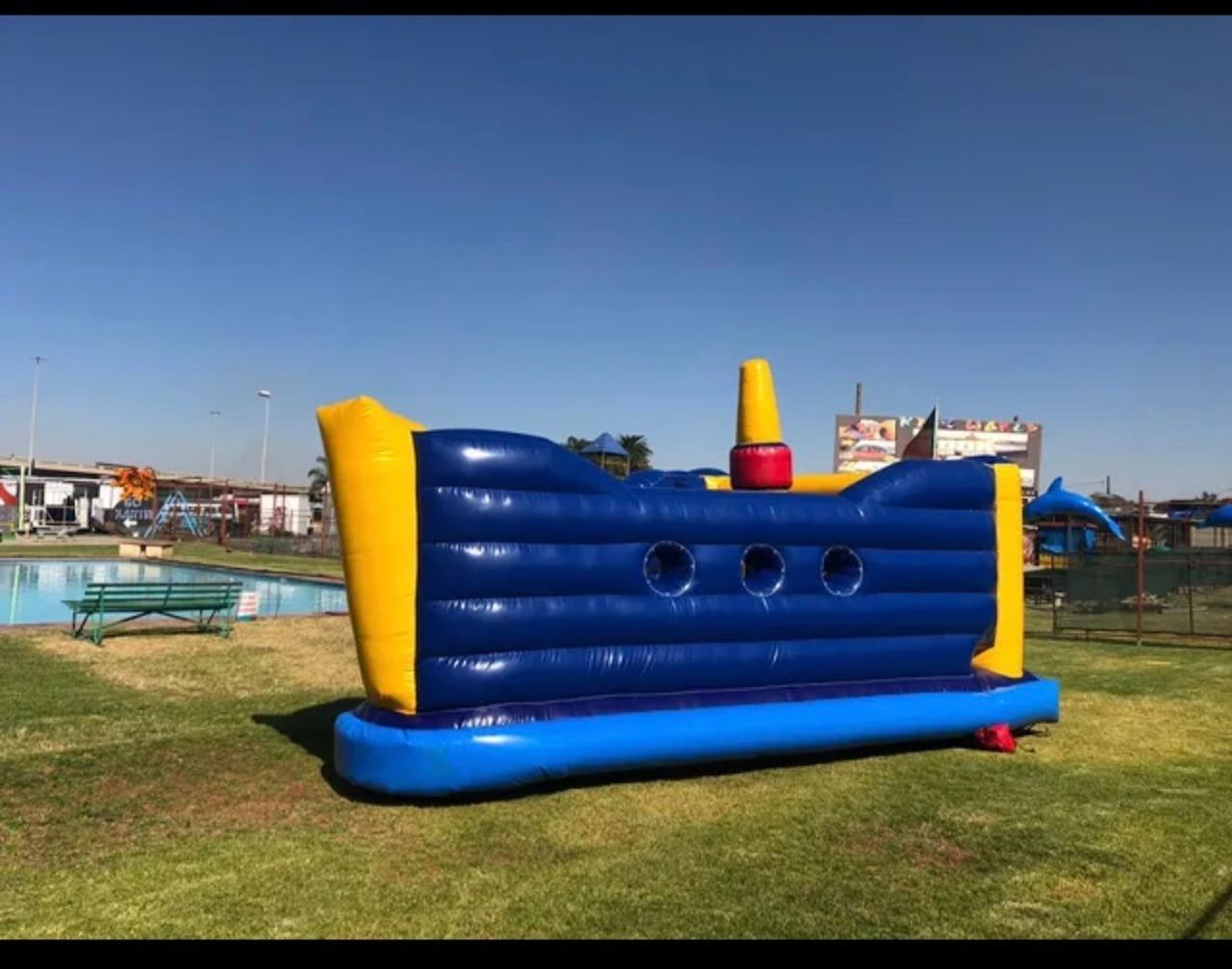 A blue and yellow bouncy house in the shape of a boat