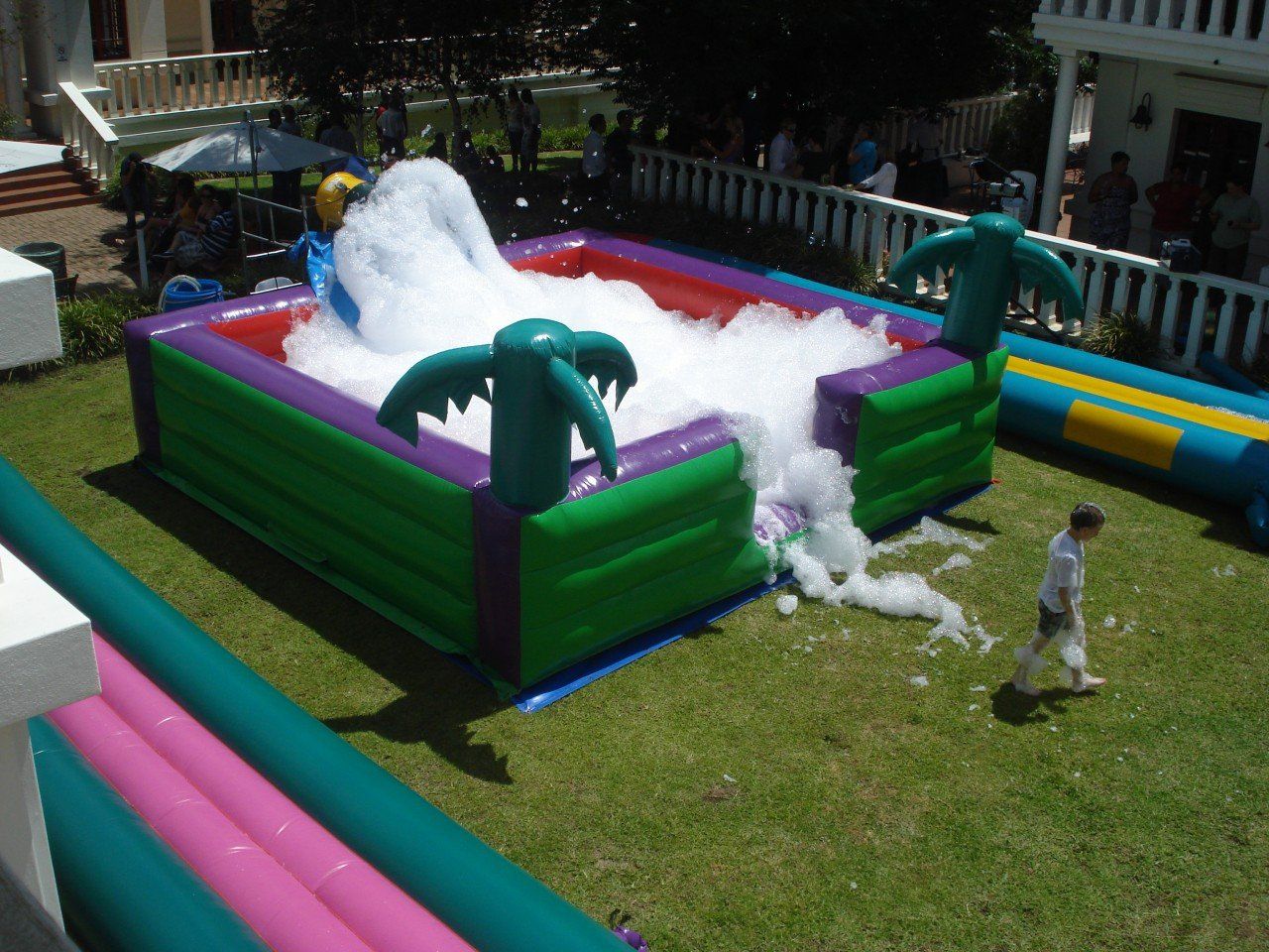 A large inflatable pool filled with foam and palm trees