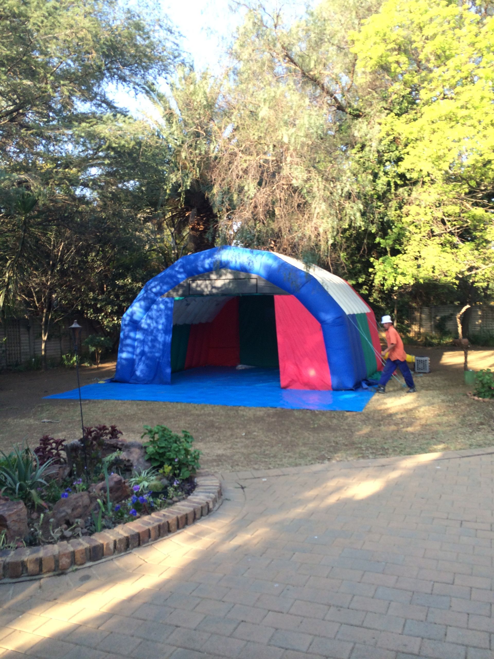 A man is standing in front of a large inflatable tent.