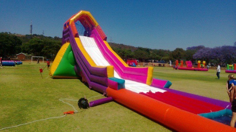 A large inflatable water slide is sitting on top of a lush green field.