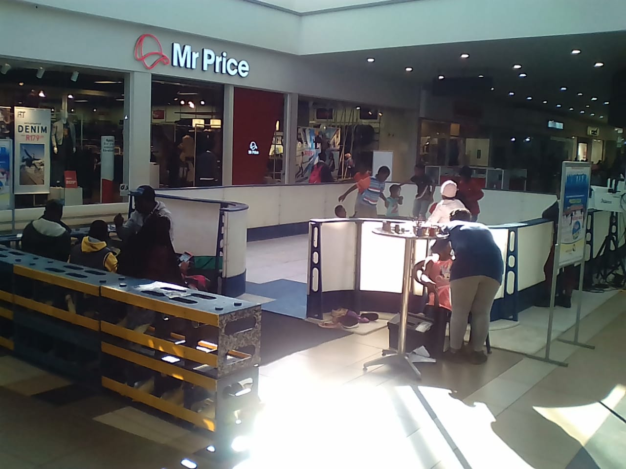 A group of people are standing in front of a mr price store
