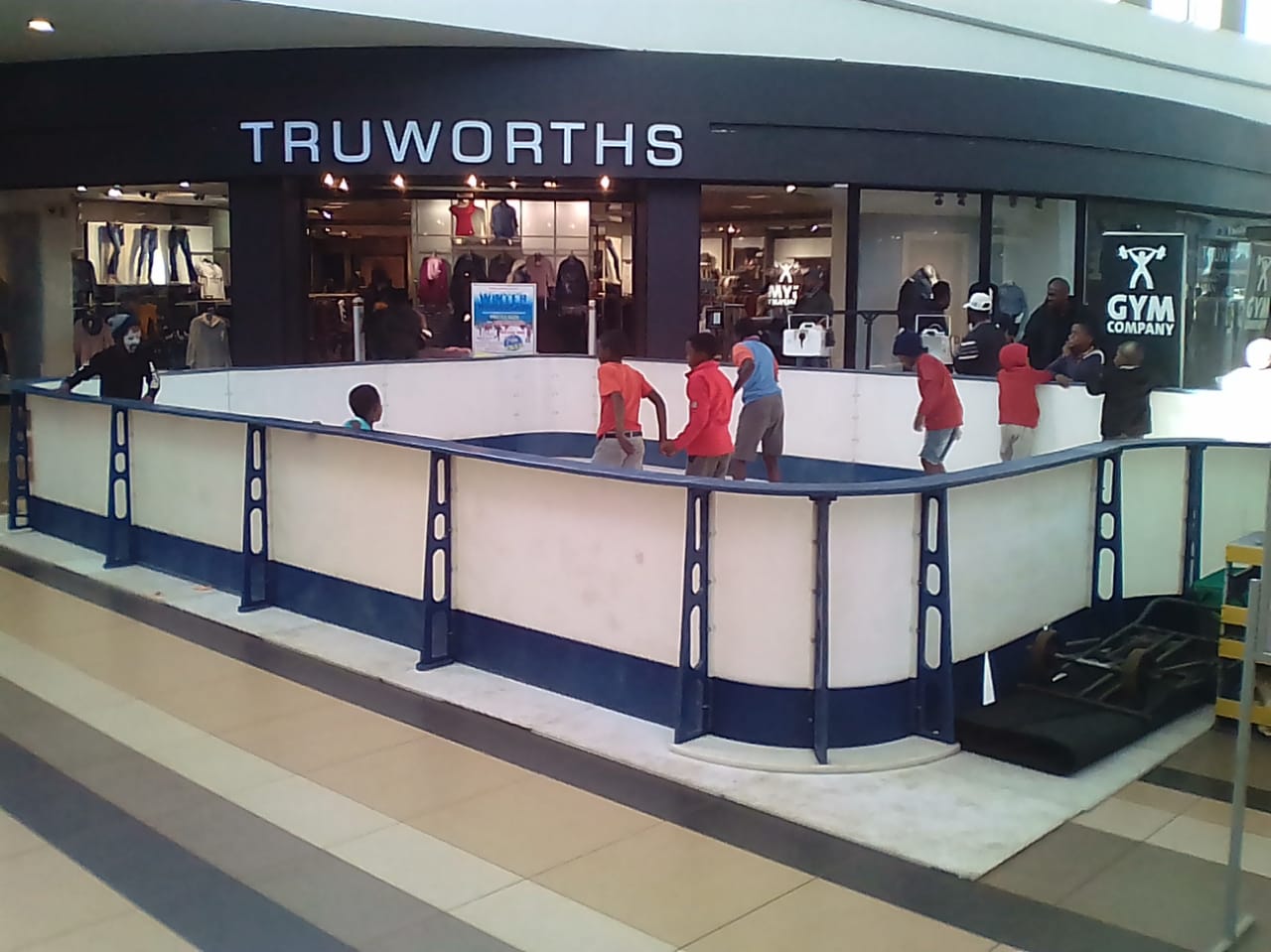 A group of children are playing in front of a truworths store