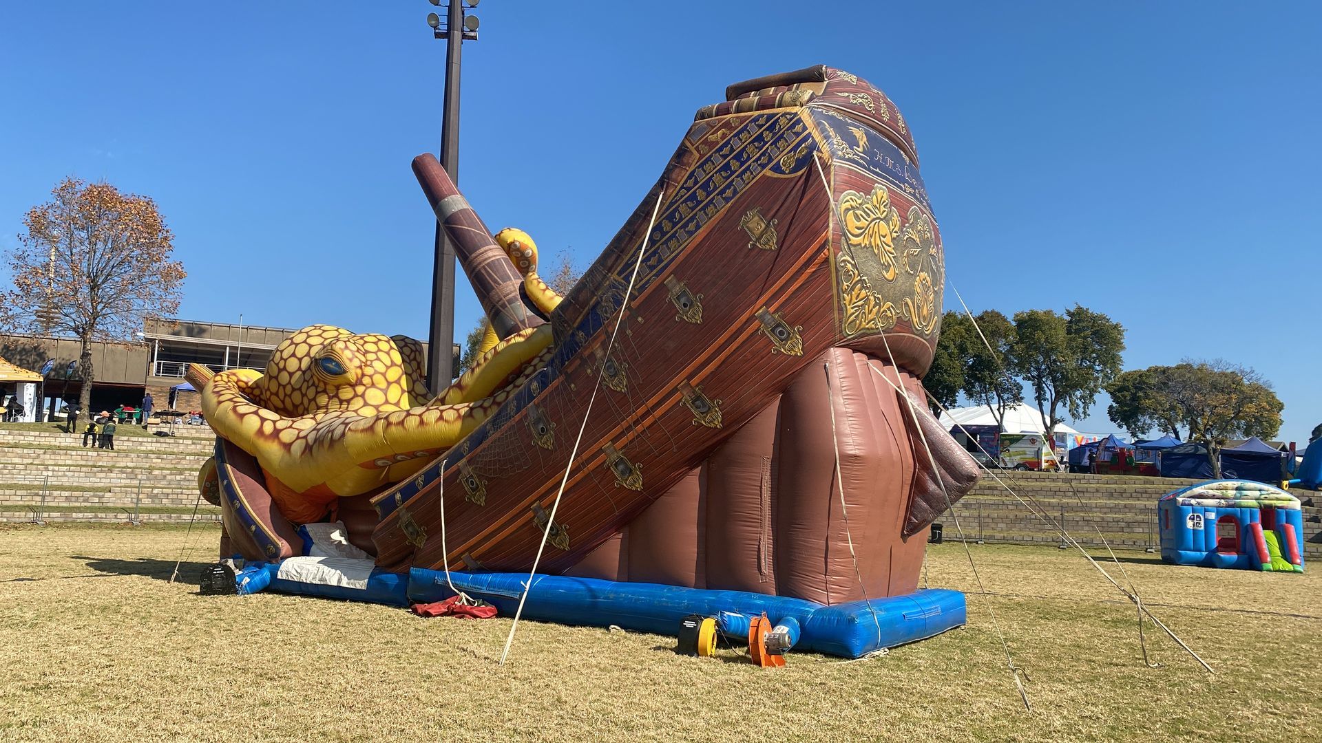 A large inflatable pirate ship is sitting on top of a grassy field.