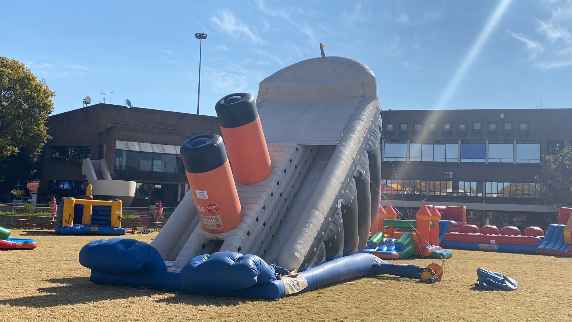 A large inflatable titanic slide is sitting on top of a lush green field.