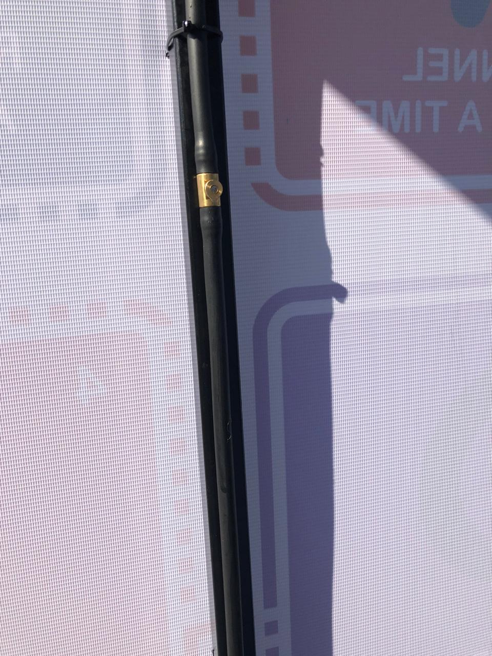 A close up of a pole with a sign in the background