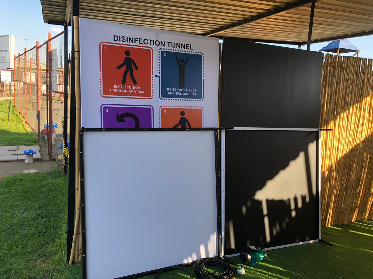 A fence with a sign on it that says disinfection tunnel