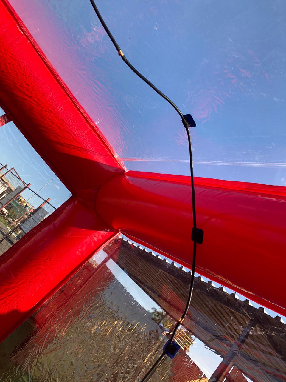A red inflatable structure with a string of lights hanging from it.