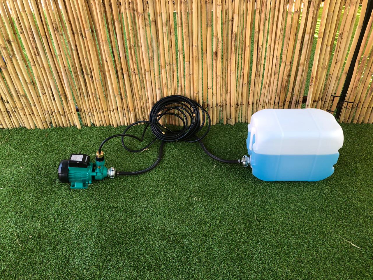 A water pump is attached to a large plastic container.