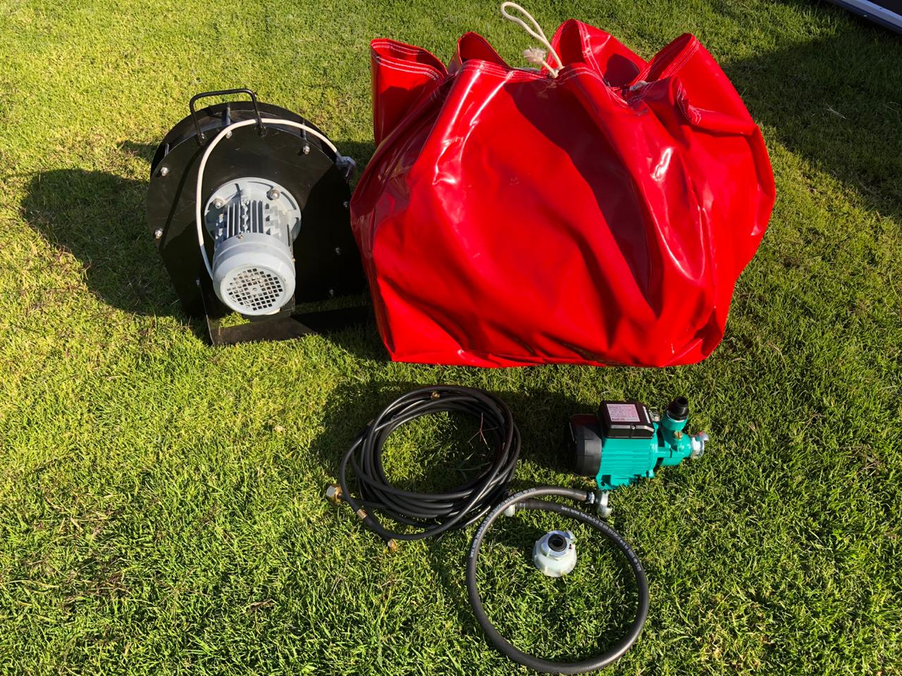 A red bag is sitting on top of a lush green field.