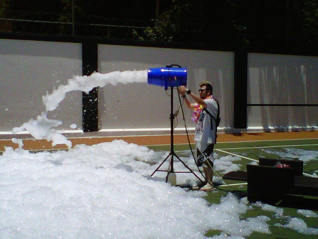 A man is spraying foam from a blue machine
