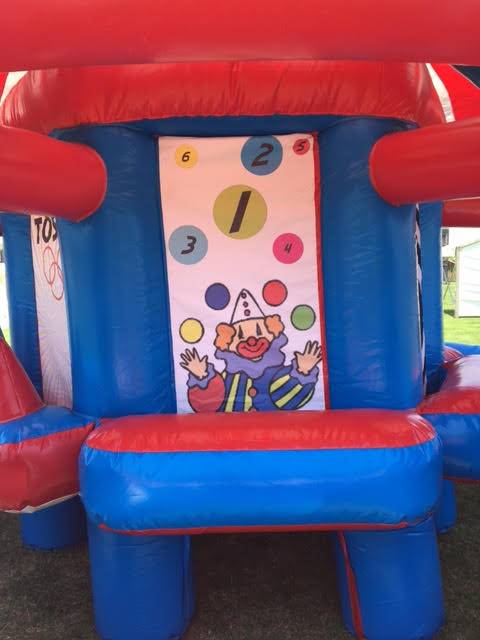 A blue and red bouncy house with a clown on it