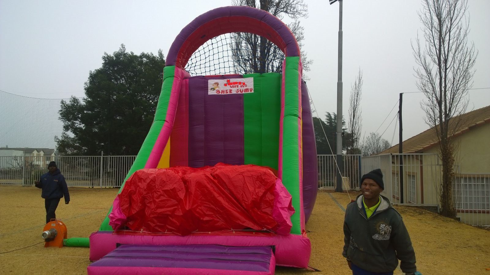 A man standing in front of a pink and green bouncy house