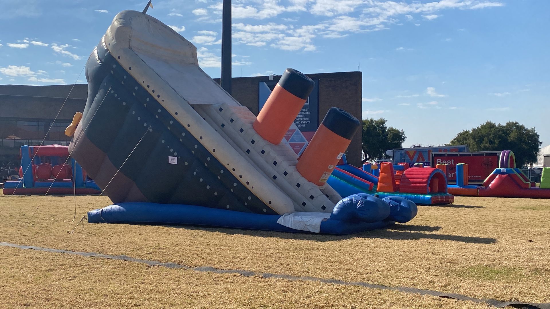 A large inflatable titanic ship is sitting on top of a field.