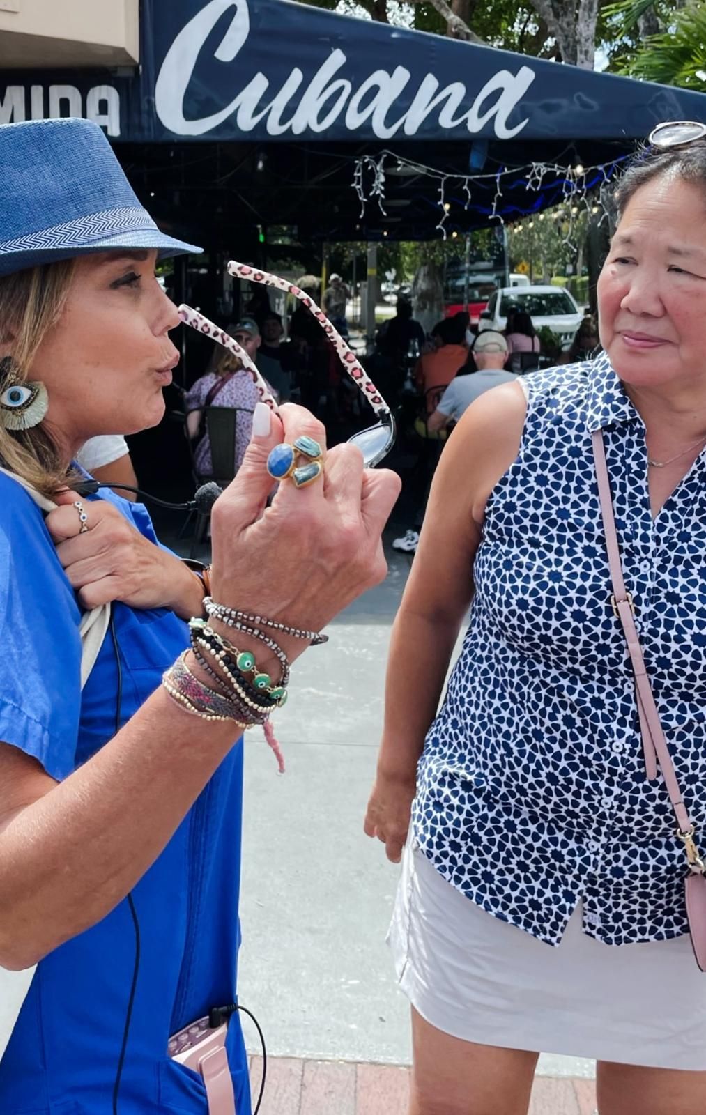 Two women are standing in front of a sign that says cubana