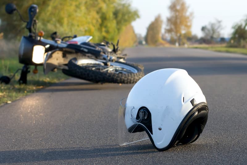 Motorcycle helmet lying next to a fallen motorcycle
