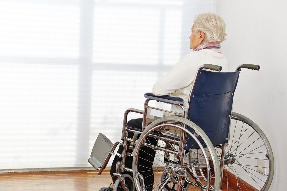Older woman in wheelchair looking out a window