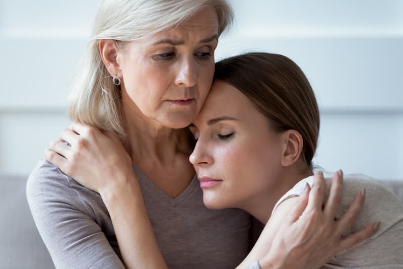 Young woman hugs distraught older woman