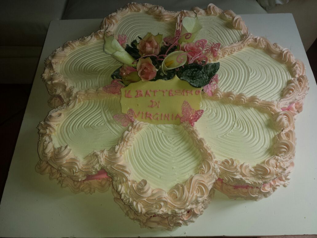 Torta a forma di fiore con glassa rosa, fiori e un messaggio per Virginia.