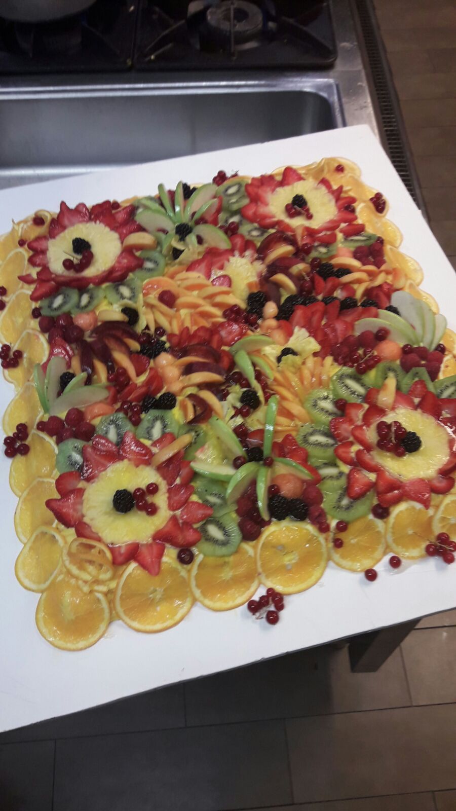 Vassoio di frutta con motivi floreali, raffiguranti arance, fragole, kiwi e frutti di bosco.