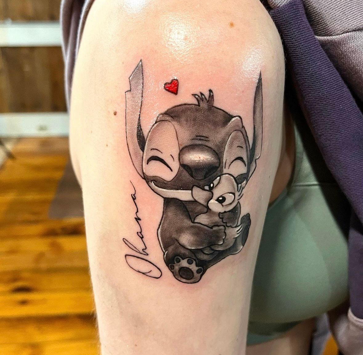 Stitch tattoo hugging a smaller Stitch, with a heart and