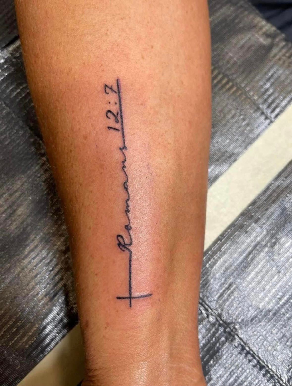 Tattoo of a cross and the words 