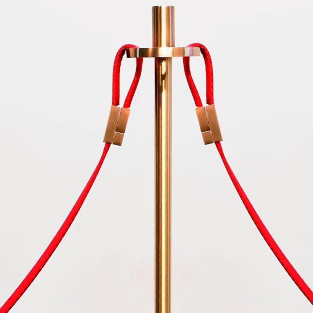 Gouden paal met rode koorden die aan een ring hangen.