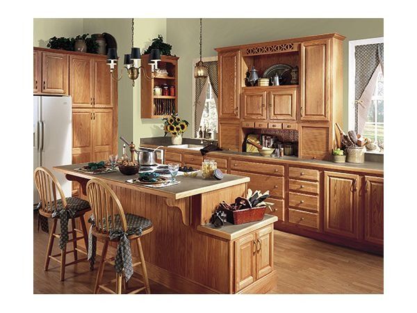 Kitchen with light wood cabinetry, island with stools, and appliances.