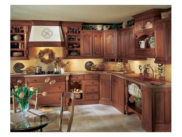 Wooden kitchen with cabinets, counter, sink, and decorative items.