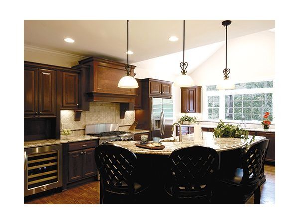 Two-story house with a brick and beige facade, dark roof, and two-car garage.