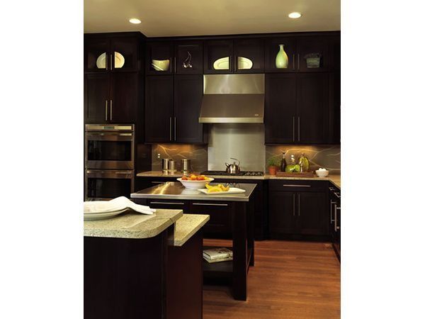 Two people shaking hands in a workshop; one in plaid shirt and hard hat, the other in denim.