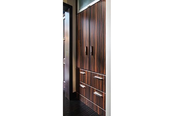 Tall wooden cabinet with two doors and two drawers in a hallway.