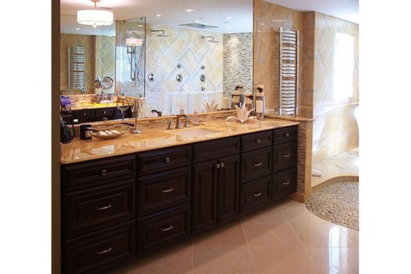 Two people shaking hands in a workshop; one in plaid shirt and hard hat, the other in denim.