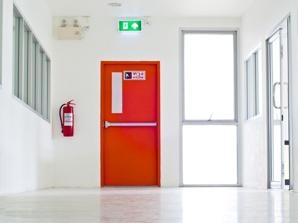 An orange door with a sign on it that says emergency exit — Locksmith in Tweed Heads, NSW