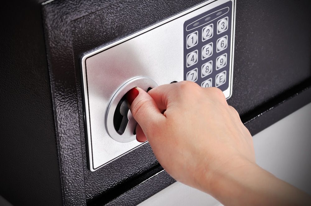 A hand is pressing a button on a digital safe — Locksmith in Tweed Heads, NSW