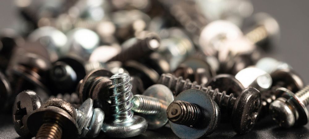 A pile of screws and nuts with a screw in the middle — Locksmith in Tweed Heads, NSW