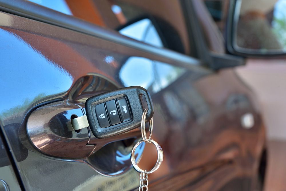 A car key is hanging from the door of a car — Locksmith in Surfers Paradise, QLD