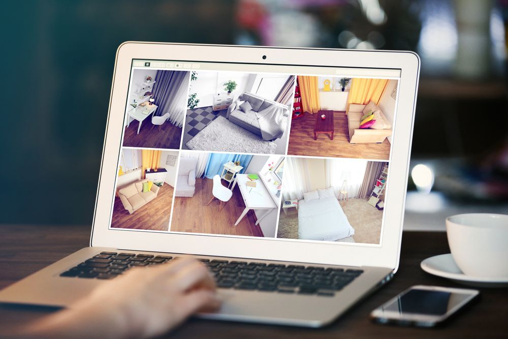 Woman is using a laptop with a collage of rooms on the screen — Locksmith in Tweed Heads, NSW