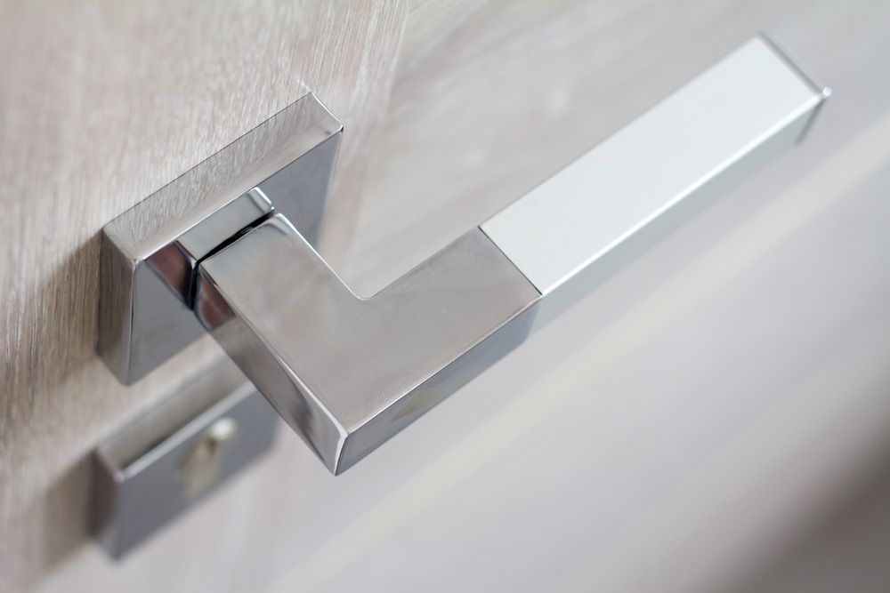 A close up of a chrome door handle on a wooden door — Locksmith in Tweed Heads, NSW
