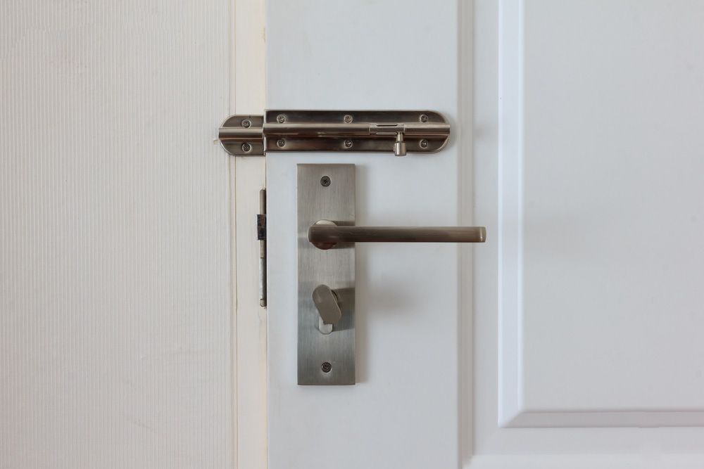 A white door with a stainless steel door handle and latch — Locksmith in Tweed Heads, NSW