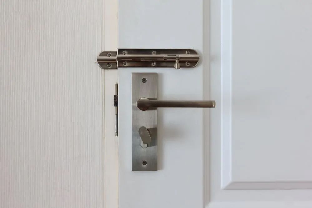 A white door with a stainless steel door handle and latch — Locksmith in Burleigh Heads, QLD