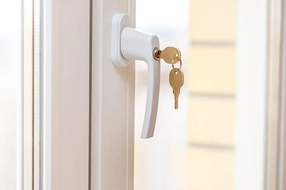 A white window handle with two keys in it — Locksmith in Burleigh Heads, QLD