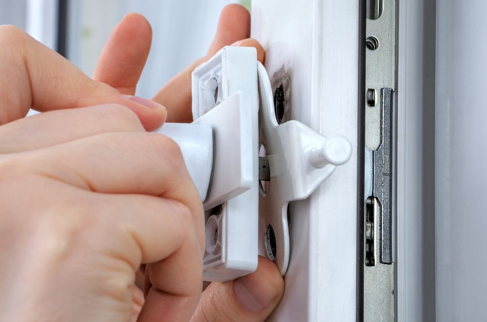 A person is installing a lock on a window — Locksmith in Currumbin, QLD