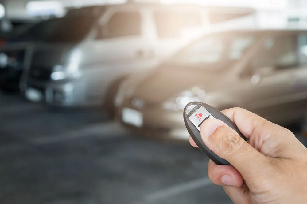 Person is holding a remote control in front of a car — Locksmith in Byron Bay, NSW