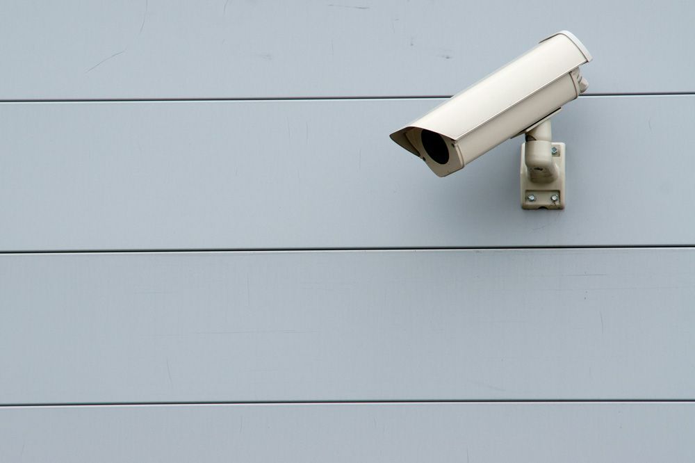 A security camera is mounted to a gray wall — Locksmith in Tweed Heads, NSW
