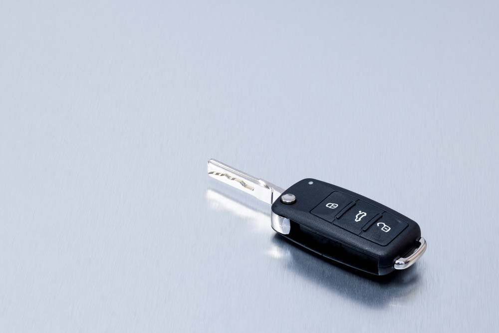 A Car Key Is Sitting On A Gray Surface — Border Locksmiths & Electronics In Tweed Heads, NSW