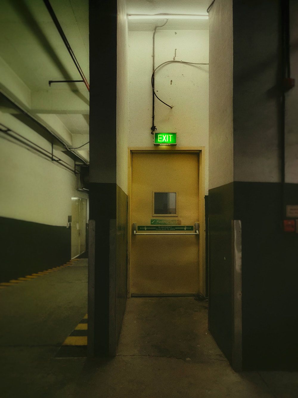 Door with a green exit sign alarm — Locksmith in Byron Bay, NSW